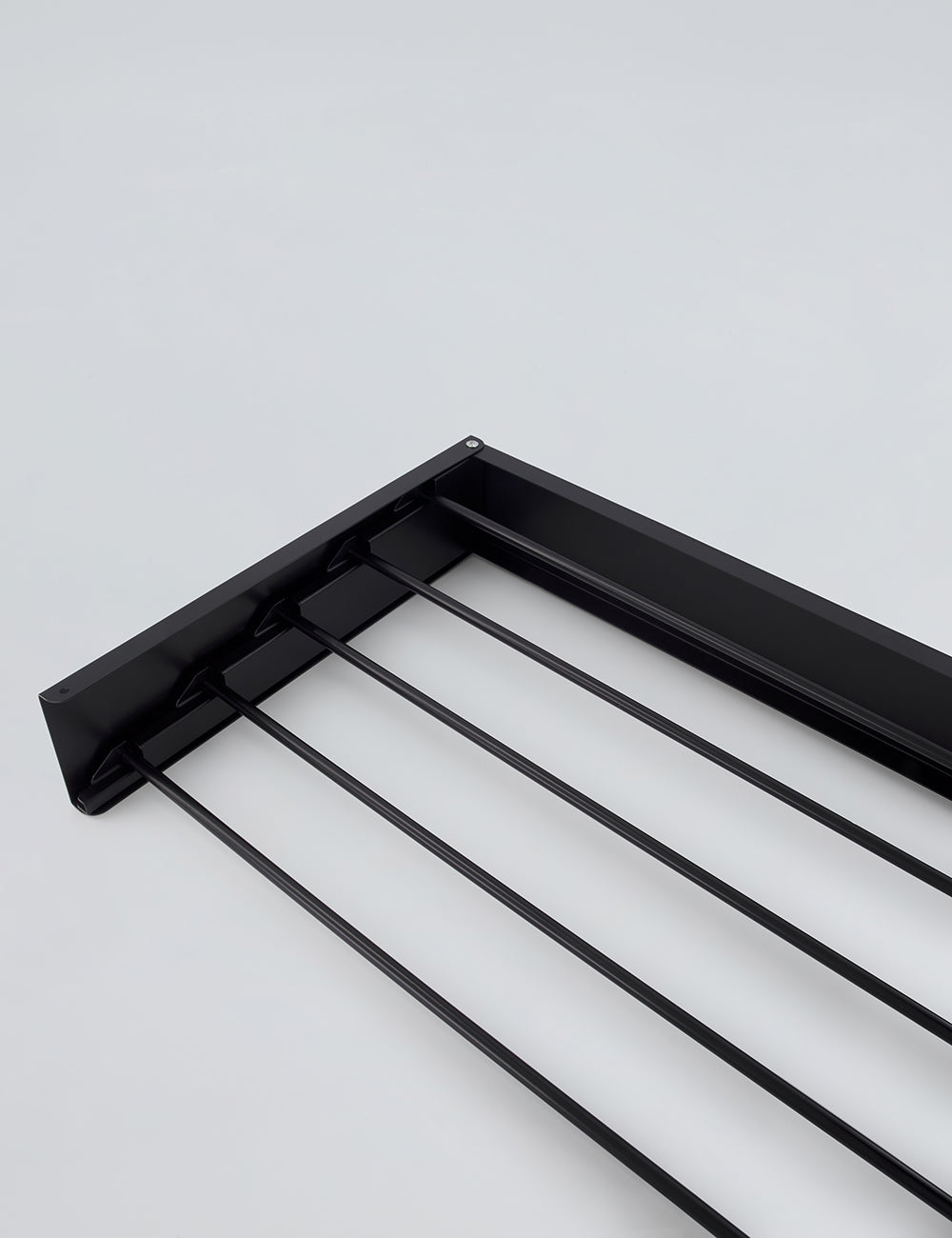 Black wall mounted drying rack folded flat against wall